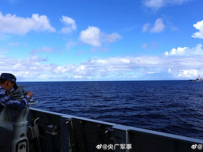 فرد من البحرية الصينية يراقب المدمرة الأميركية USS Benfold لدى إبحارها في بحر الصين الجنوبي - military.cnr.cn