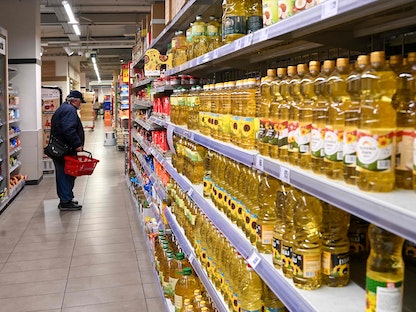 أحد العملاء ينظر إلى معلومات المنتجات أثناء التسوق في سوبر ماركت في بودابست - 1 فبراير 2022 - AFP