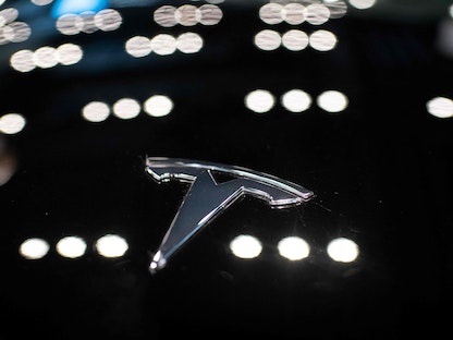شعار شركة "تسلا" يظهر على سيارة طراز "Tesla 3" داخل أحد متاجر الشركة داخل مركز تسوق في بكين الصين. 26 مايو 2021 - AFP