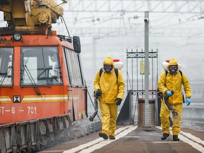 عاملان يرتديان معدات الحماية أثناء تعقيم محطة كازانسكي في العاصمة الروسية موسكو وسط تفشي كورونا - 2 نوفمبر 2021 - REUTERS