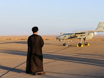 إيراني يقف بالقرب من طائرة مسيرة خلال تمرين عسكري في مكان غير معروف في إيران- 24 أغسطس 2022 - via REUTERS