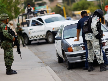 عناصر من الجيش المكسيكي والحرس الوطني يفحصون سيارة عند نقطة تفتيش عسكرية في مدينة سيوداد خواريز - 16 أغسطس 2022 - REUTERS