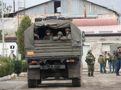 جنود حفظ سلام روس يجلسون في شاحنة عسكرية بالقرب من إقليم قره باغ المتنازع عليه بين أرمينيا وأذربيجان- 13 نوفمبر 2020 - REUTERS