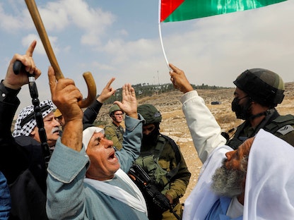 فلسطينيون يتظاهرون أمام قوت إسرائيلية ضد خطط إقامة مستوطنات جديدة بمنطقة مسافر يطا - الضفة الغربية - 2 أكتوبر 2021 - REUTERS