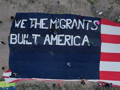 مهاجرون من فنزويلا يفرشون لافتة كبيرة على شكل علم الولايات المتحدة للاحتجاج على سياسات الهجرة الجديدة المكسيك - 30 أكتوبر 2022 - REUTERS