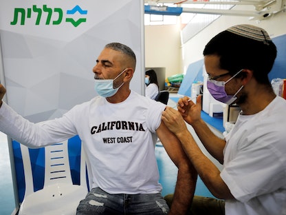 شاب يلتقط صورة سيلفي أثناء تلقيه اللقاح ضد فيروس كورونا في مركز صحي بمدينة نتيفوت، إسرائيل، 4 فبراير 2021 - REUTERS