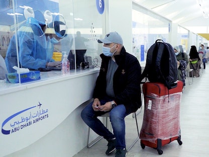 مسافر خلال إجراء فحص PCR عند وصوله مطار أبوظبي - twitter/Abu Dhabi Airport