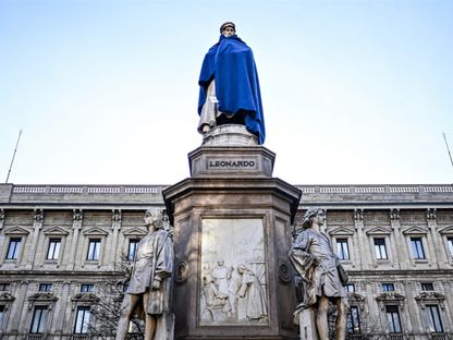 تمثال دافنشي في ميلانو مغطى بالأزرق في إطار حملة لدعم المشرّدين في البلاد. 14 فبراير 2024 - AFP