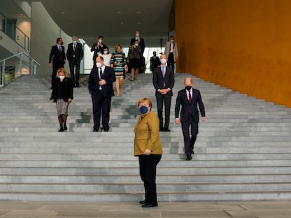 المستشارة الألمانية بالإنابة أنجيلا ميركل مع أعضاء حكومتها لالتقاط صورة جماعية بعد الاجتماع الأسبوعي لمجلس الوزراء في المستشارية في برلين - 24 نوفمبر 2021 - REUTERS