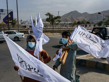 شابان يبيعان أعلام طالبان في كابول بعد سيطرة الحركة على العاصمة - 20 أغسطس 2021 - Getty Images