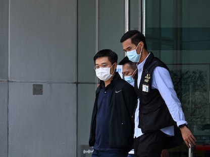 رايان لو  رئيس تحرير صحيفة "أبل ديلي" رفقة الشرطة خارج مكاتب الصحيفة في هونغ كونغ- 17 يونيو 2021 - AFP