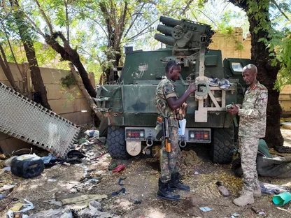 أفراد من الجيش السوداني يقفون بجانب مركبة عسكرية مدمرة بعد معركة مع قوات الدعم السريع في العاصمة الخرطوم، السودان. 25 مارس 2025 - Reuters