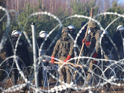 عناصر من الأمن البولندي على الحدود بين بولندا وبيلاروسيا حيث يحتشد آلاف المهاجرين في محاولة للعبور باتجاه دول الاتحاد الأوروبي 9 نوفمبر 2021 - AFP