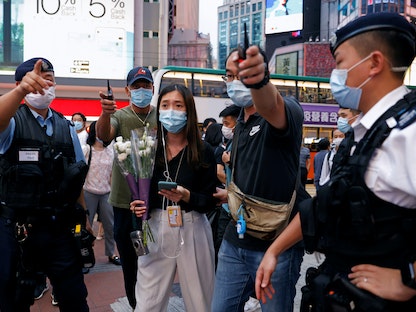 شرطيون في هونغ كونغ يمنعون امرأة تحمل زهوراً من تكريم رجل طعن شرطياً قبل أن ينتحر - 2 يوليو 2021 - REUTERS