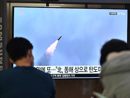 شخصان يشاهدان تقريراً تلفزيونياً عن إطلاق كوريا الشمالية مقذوفات قرب المنطقة المنزعة السلاح بين سول وبينج يانج - 29 سبتمبر 2022 - AFP