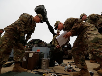 جنود أميركيون يفحصون معدات عسكرية بعد نشرهم في بولندا لإجراء تدريبات عسكرية - بومورسكي-  بولندا - 21 مارس 2019 - REUTERS