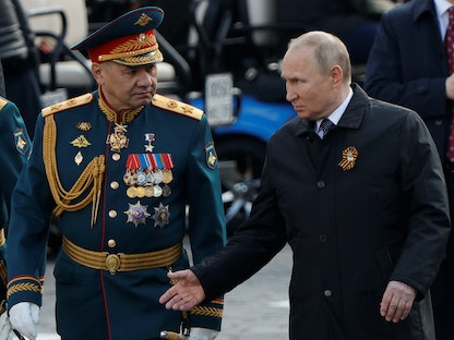   الرئيس الروسي فلاديمير بوتين ووزير الدفاع سيرجي شويجو يتحدثان بعد عرض عسكري في يوم النصر - 9 مايو 2022 - REUTERS