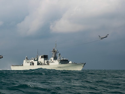 طائرة هليكوبتر من طراز CH-148 Cyclone وطائرة دورية بحرية CP-140 Aurora تحلق فوق فرقاطة بحرية ملكية كندية كجزء من تمرين "عملية نيون"- 15 نوفمبر 2020 - REUTERS