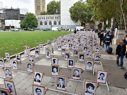 الجالية الإيرانية في بريطانيا تقيم نصباً تذكارية لضحايا "مذبحة 1988" ضد السجناء السياسيين في إيران، ساحة البرلمان، لندن- 4 أكتوبر 2019 - Getty Images