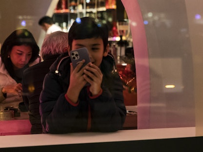 أشخاص يستخدمون هواتفهم الذكية في مدينة شنغهاي، الصين - Bloomberg