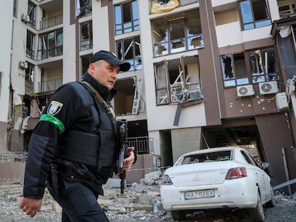 شرطي يمر بجوار مبنى سكني دمر في غارة عسكرية وسط الغزو الروسي لأوكرانيا في كييف، أوكرانيا 29 أبريل 2022 - REUTERS
