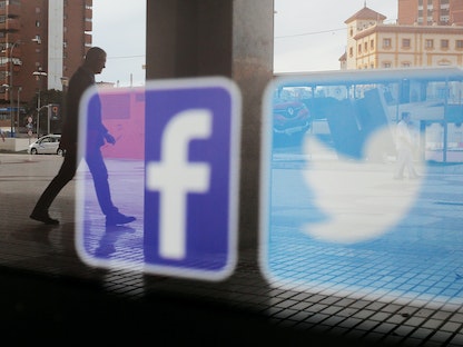 شعارا "فيسبوك" و"تويتر" يظهران على نافذة متجر في إسبانيا - 4 يونيو 2018 - REUTERS