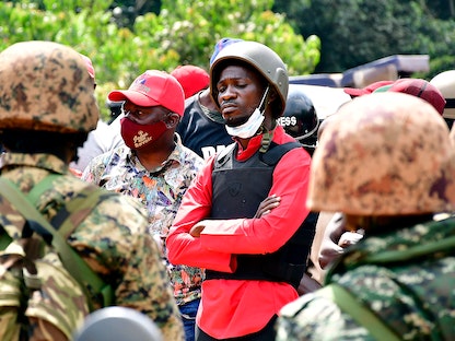 المرشح الرئاسي الأوغندي المعارض روبرت كياغولاني  المعروف أيضاً باسم بوبي واين برفقة رجال الشرطة أثناء اعتقاله في كالانغالا- 30 ديسمبر 2020 - REUTERS