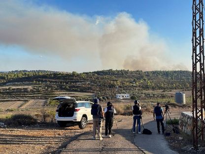 صحافيون يصورون قصفاً إسرائيلياً على الحدود اللبنانية الإسرائيلية. 13 أكتوبر 2023 - REUTERS