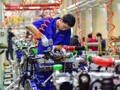 عمال في شركة لتصنيع المحركات في مدينة تشنجتشو بمقاطعة شاندونج شرقي الصين. 31 أغسطس 2023 - AFP