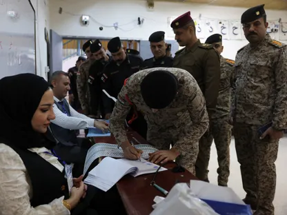أحد أفراد الأمن العراقي يوقع على وثائق خلال التصويت الخاص بقوات الأمن قبل بدء الانتخابات البرلمانية في بغداد. 9 نوفمبر 2025 - Reuters