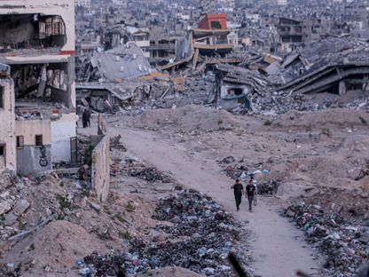 يتفقد الفلسطينيون المباني المدمرة بعد الهجوم الإسرائيلي على حي الدرج مع استمرار الهجمات الإسرائيلية في مدينة غزة، 20 أبريل 2024 - AFP