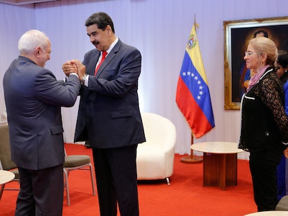 الرئيس الفنزويلي نيكولاس مادورو يصافح وزير الخارجية الإيراني محمد جواد ظريف في كاراكاس- 20 يوليو  2019 - REUTERS