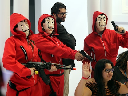 فنانون يرتدون ملابس ممثلين في سلسلة "La Casa de Papel" يؤدون عرضاً خلال تجربة ساو باولو كوميك كون في ساو باولو، البرازيل- 6 ديسمبر 2018. - REUTERS