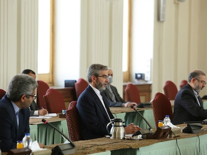 مساعد وزير الخارجية الإيراني للشؤون السياسية علي باقري (وسط) يلتقي منسق الاتحاد الأوروبي بشأن المحادثات النووية إنريكي مورا في طهران - REUTERS
