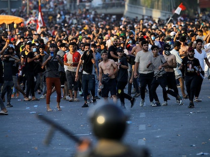 متظاهرون يواجهون قوات الأمن خلال احتجاجات مناهضة للحكومة في العاصمة العراقية بغداد، 25 مايو 2021 - REUTERS