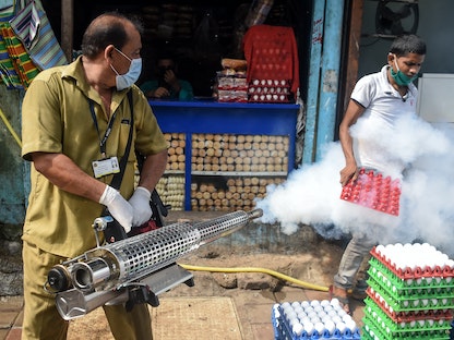 عامل مدني يرش الدخان في منطقة فقيرة كإجراء وقائي ضد الملاريا وحمى الضنك قبل الرياح الموسمية في مومباي الهند - 12 يونيو 2020 - AFP