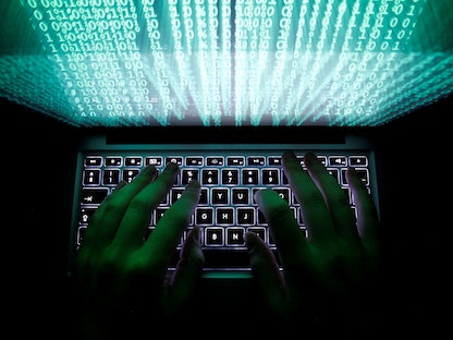 صورة توضيحية لشخص يستخدم لوحة مفاتيح جهاز كمبيوتر في محاكاة لعمليات القرصنة - REUTERS