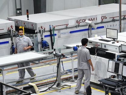 عمّال سعوديون في مصنع للوحات الشمسية شمال العاصمة السعودية الرياض. - AFP