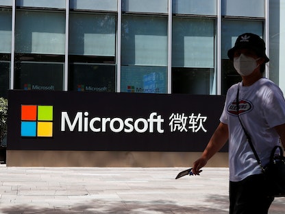 شخص يمر بجانب شعار مكتب مايكروسوفت في بكين - REUTERS