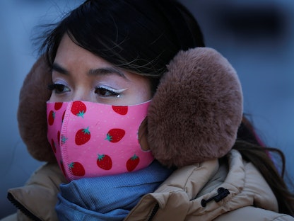 امرأة ترتدي ملابس ثقيلة مع انخفاض درجات الحرارة في مانهاتن بمدينة نيويورك- 26 يناير 2022 - REUTERS