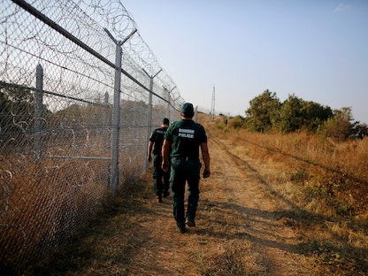 عناصر من شرطة الحدود البلغارية يسيرون بمحاذاة سياج من الأسلاك الشائكة تم تشييده على الحدود مع تركيا، 14 سبتمبر 2016 - REUTERS