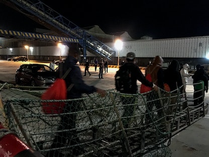 مهاجرون ينزلون من السفن في جزيرة صقلية الإيطالية - AFP