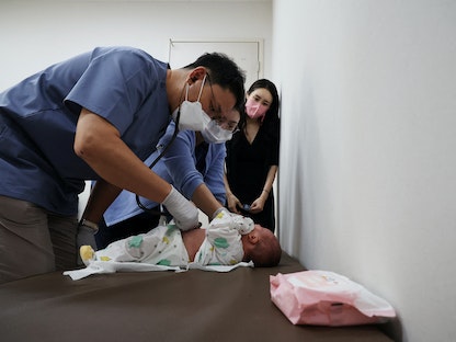 طبيب أطفال يفحص رضيعاً في عيادة للأطفال في سول، كوريا الجنوبية. 14 يونيو 2023 - REUTERS