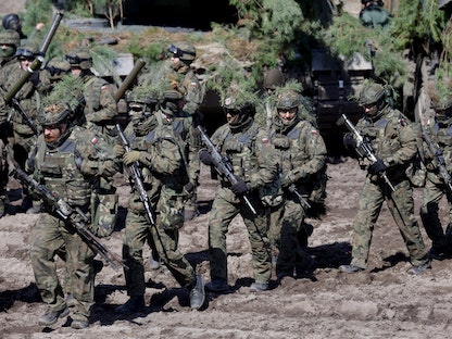جنود أميركيون وبولنديون يشاركون في تدريب عسكري مشترك بمدينة نوا ديبا جنوب شرق بولندا - 8 أبريل 2022 - REUTERS