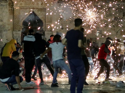 جانب من المواجهات بين مدنيين فلسطينيين وقوات إسرائيلية مسلحة داخل إحدى باحات المسجد الأقصى - REUTERS