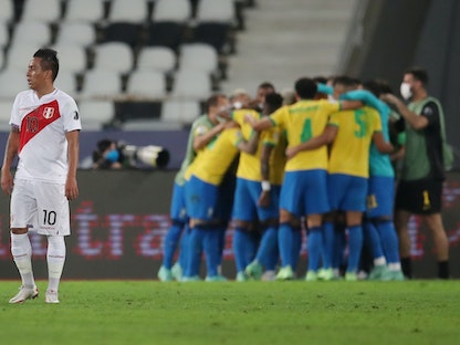 لاعبو البرازيل يحتفلون بالهدف الذي سجله لوكاس باكيتا بينما يظهر اللاعب البيروفي كريستيان كويفا - REUTERS