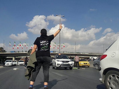 ناشط إيراني يرتدي قميصاً كُتب عليه بالفارسية "سنقاتل، وسنموت، وسنستعيد إيران" في مدينة كرج. 3 نوفمبر 2022 - AFP