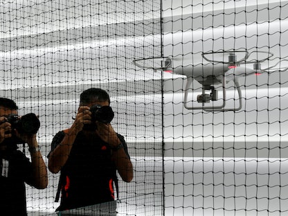مصورون يلتقطون صوراً لطائرة بدون طيار تحلق في المتجر الرئيسي لشركة DJI في هونج كونج. 22 سبتمبر 2016 - REUTERS