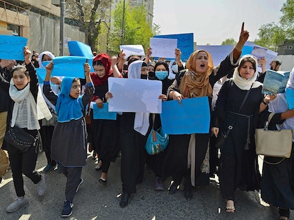 نساء وفتيات يشاركن في احتجاج أمام وزارة التعليم، كابول أفغانستان - 26 مارس 2022. - AFP
