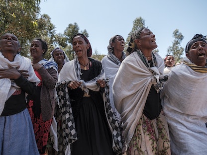 نساء إثيوبيات يبكين ضحايا مجزرة يُزعم أن جنوداً إريتريين ارتكبوها في قرية دينقولات شمال ميكيلي بإقليم تيغراي - 26 فبراير 2021 - AFP
